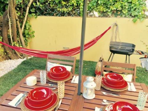 a wooden table with red plates on top of it at BS VILLAS RC PORTO in Porto