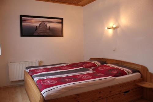 ein Schlafzimmer mit einem Bett mit roten Kissen darauf in der Unterkunft Wangeroogeweg 3a in Wangerland
