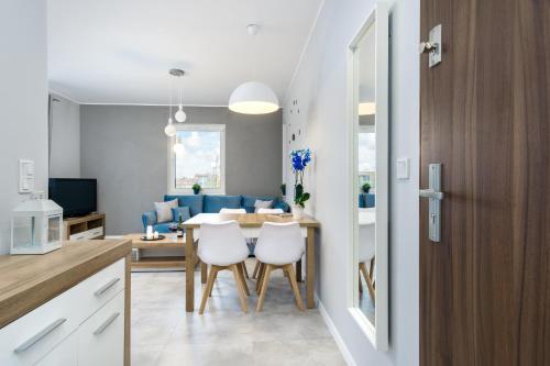 a kitchen and living room with a table and chairs at Elite Apartments Family City Center in Gdańsk