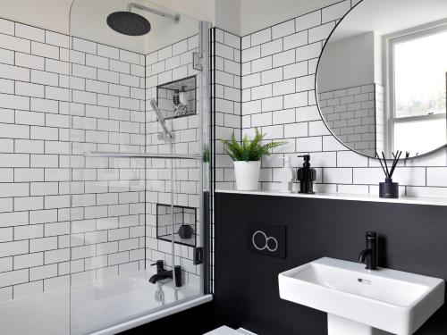 a white bathroom with a sink and a mirror at Student Castle Studio Apartments - Free parking in Bath