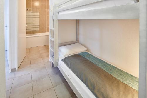 a bedroom with a bunk bed in a room at Résidence Vacances Bleues Les Jardins d'Arvor in Bénodet
