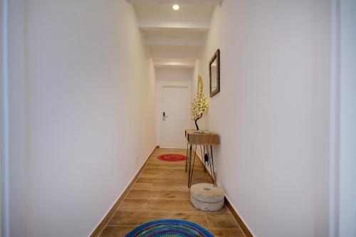 a hallway with a white wall and a table at Yellow Barqueta Studio in Faro
