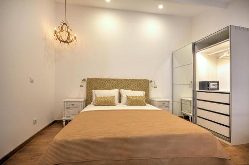 a bedroom with a large bed and a chandelier at Yellow Barqueta Studio in Faro