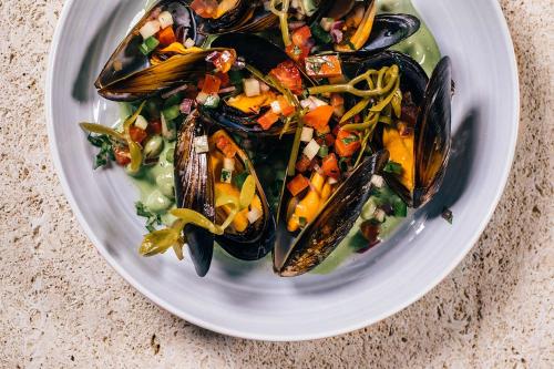 a plate of food with mussels and other vegetables at Can Bordoy Grand House Hotel GL Preferred Hotel in Palma de Mallorca