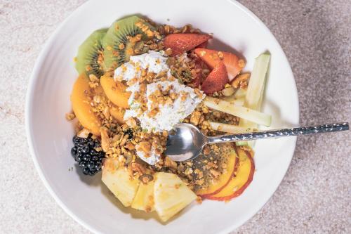a white plate of food with fruit and a spoon at Can Bordoy Grand House Hotel GL Preferred Hotel in Palma de Mallorca