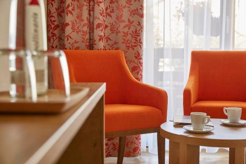 a room with two chairs and a table with cups at Gästehaus Goethe in Staufen im Breisgau