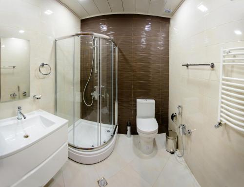 een badkamer met een douche, een toilet en een wastafel bij AZPETROL HOTEL QUSAR in Qusar