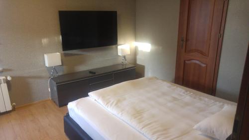 a hotel room with a bed and a flat screen tv at Hotel Folwark in Zgierz