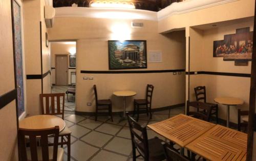 ローマにあるBel soggiornoのテーブルと椅子が備わるレストラン