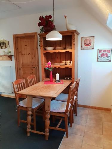 ein Esszimmer mit einem Holztisch und Stühlen in der Unterkunft Gästehaus Alwine Wohnung 6 in Grömitz