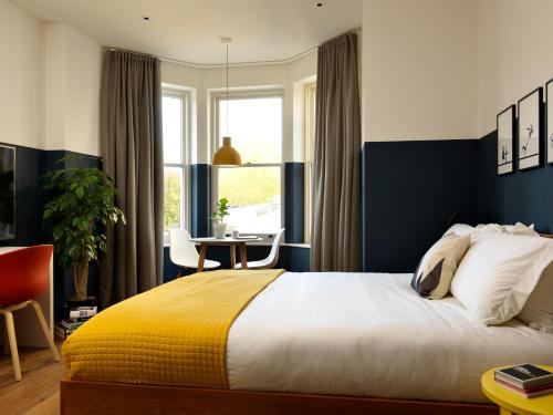 a bedroom with a bed with a yellow and blue wall at Student Castle Studio Apartments - Free parking in Bath