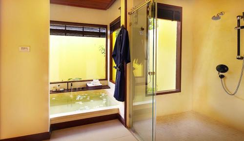 a bathroom with a shower and a tub with a window at Chantaramas Beach Resort Koh Phangan in Baan Khai