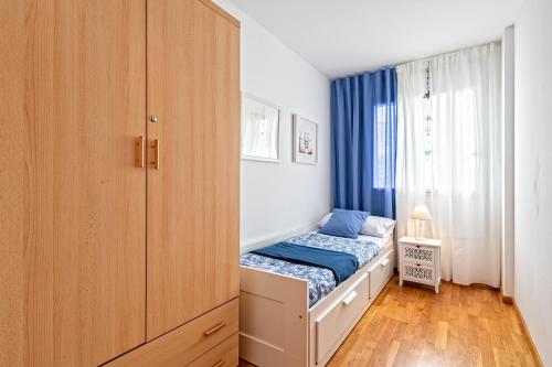a small bedroom with a bed and a cabinet at Cálido apartamento con piscina en Barcelona in Ripollet
