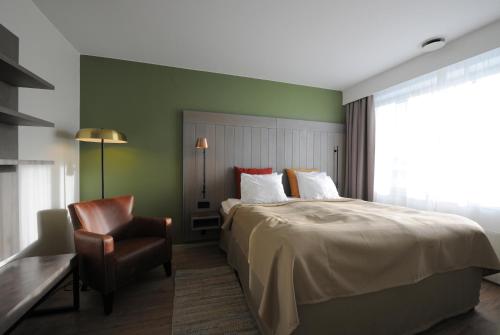 a hotel room with a bed and a chair at Quality Hotel Grand Falun in Falun