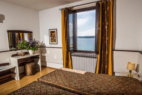 ein Schlafzimmer mit einem Bett und einem großen Fenster in der Unterkunft Hotel Kastel in Crikvenica