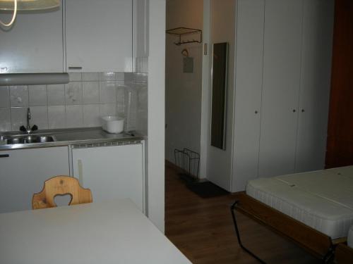 a small kitchen with a sink and a bed in a room at Studio Bündawiese 6 in Davos