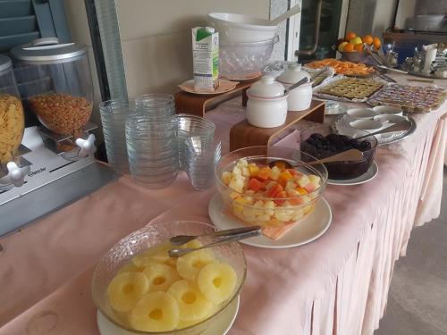 a table with bowls of fruit and plates of food at Hotel Bettina in Mergozzo