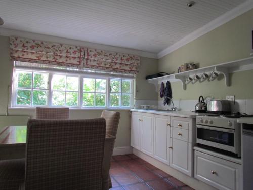 a kitchen with white cabinets and a stove top oven at High Hopes in Greyton