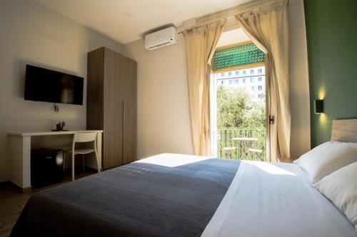 a bedroom with a bed and a window and a desk at Interno 10 Cavour in Naples