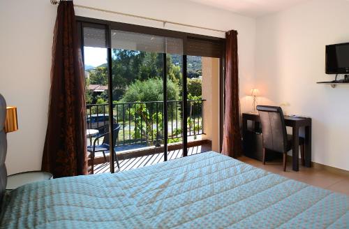 a bedroom with a bed and a view of a balcony at Hôtel l'Alivu in Galeria