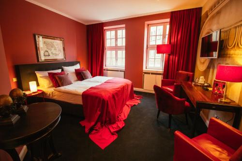 Dormitorio rojo con cama, escritorio y sillas en Boutique Hotel Classico Bremen, en Bremen