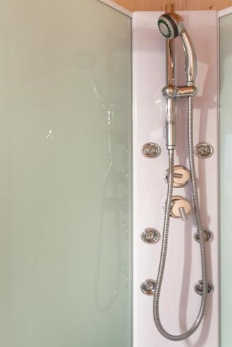 a shower with a shower head in a bathroom at Apartments near metro station in Vienna