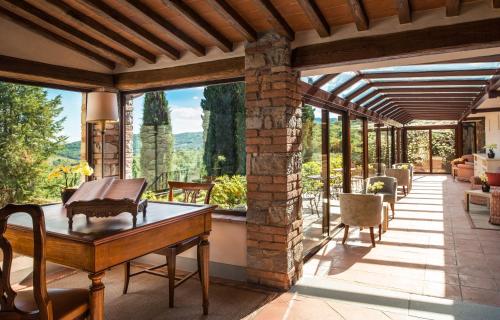 a conservatory with a table and chairs on a patio at Castello di Spaltenna Exclusive Resort & Spa in Gaiole in Chianti