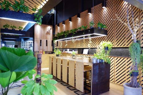 a restaurant with a bar with potted plants at Hugger Hostel in Phuket