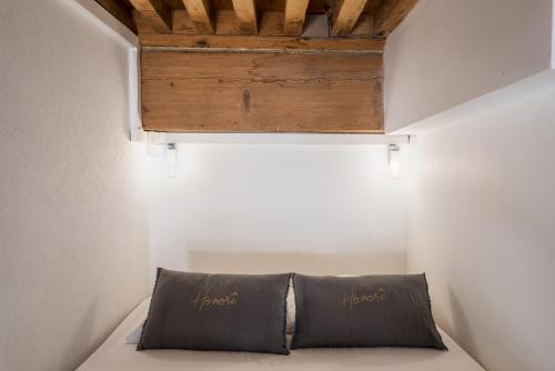 リヨンにあるHonorê - Suite Mercièreの木製の天井の客室のベッド1台分です。