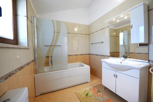 a bathroom with a tub and a sink and a shower at Villa Kmacici 377 in Sveti Lovreč Pazenatički