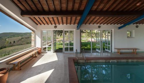 an indoor pool with a view of a house at Castello di Spaltenna Exclusive Resort & Spa in Gaiole in Chianti