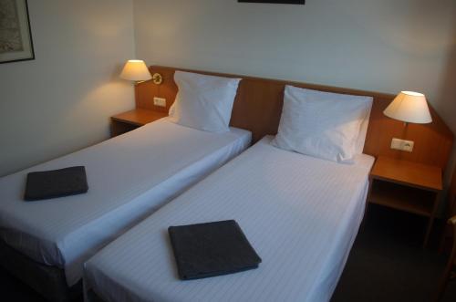 Dos camas en una habitación de hotel con una bandeja negra. en Niedereher Mühle, en Niederehe