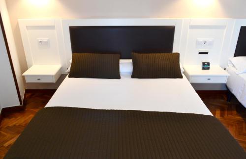 a bedroom with a large white bed with two pillows at Hotel Alda Santa Cristina in Perillo