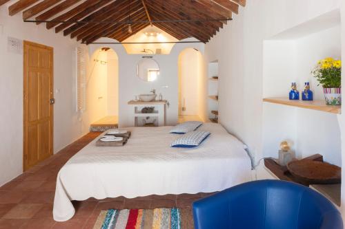 コンペタにあるBed&Breakfast Al Campanarioのベッドルーム(大型ベッド1台、青い椅子付)