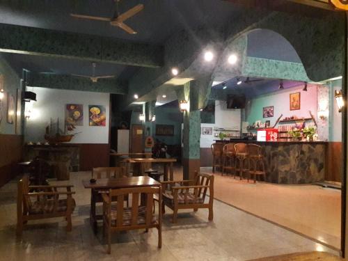 a restaurant with wooden tables and chairs and a bar at JP hometel in Krabi