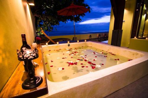 a bath tub filled with flowers in a room at Chantaramas Beach Resort Koh Phangan in Baan Khai