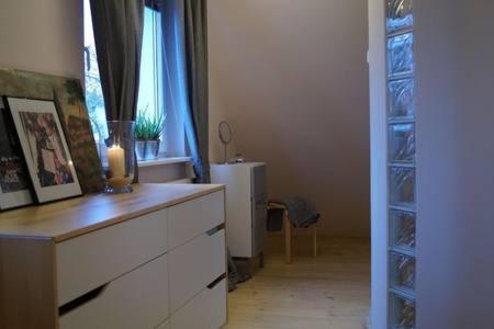 a room with a dresser and a window with a candle at Cherry Tree Guest House in Gdańsk