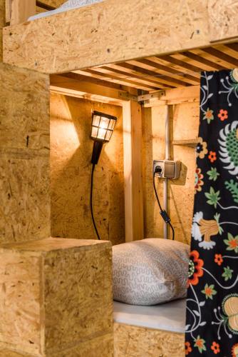 a lamp in a room with a bed in a wall at Stay Swanky Hostel in Zagreb
