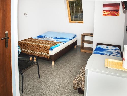 ヤロスワビエツにあるArkadia Wypoczynek i Odstresowanieのベッドと椅子が備わる小さな客室です。