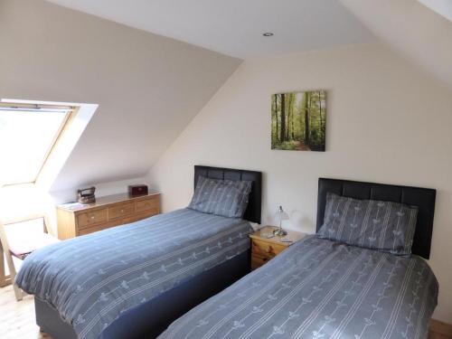 - 2 lits installés l'un à côté de l'autre dans une chambre dans l'établissement Clifton Cottage B&B, à Tyndrum