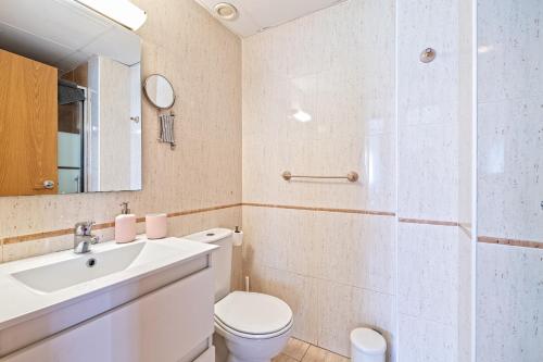 a bathroom with a sink and a toilet and a mirror at Apartamento lujo& piscina junto Barcelona Centro in Ripollet