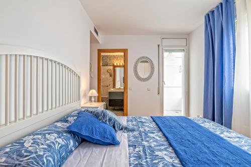 - une chambre avec un lit bleu et des oreillers bleus dans l'établissement Apartamento lujo& piscina junto Barcelona Centro, à Ripollet