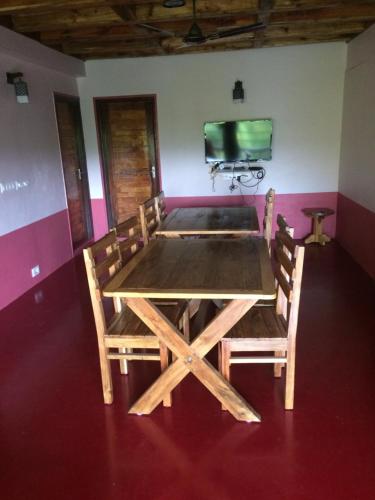 a wooden table and chairs in a room with a tv at IBBANI Homestay, Siddapur in Siddāpur