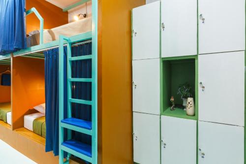 a room with bunk beds with blue and white cabinets at Aekkeko hostel in Phuket Town