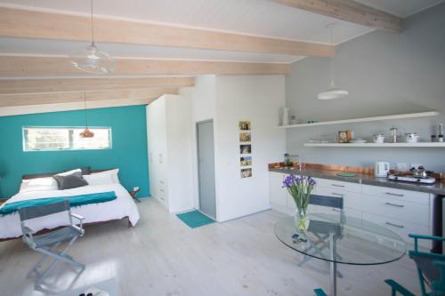 a bedroom with a bed and a glass table at Selkie - Two Restful Studio Apartments near Noordhoek Beach & Restaurants in Noordhoek