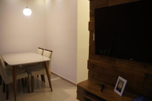 a dining room with a table and a flat screen tv at Apartamento Completo em Cotia - SP in Cotia