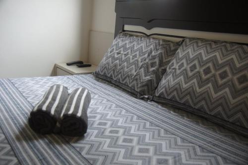 Una cama con un par de calcetines. en Apartamento Completo em Cotia - SP en Cotia