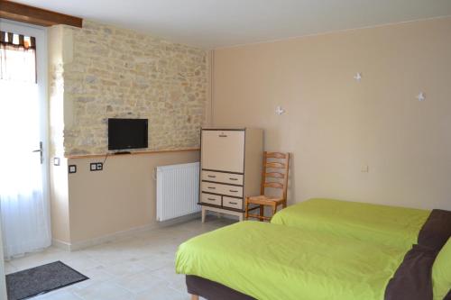 1 dormitorio con 2 camas y TV en la pared en La Fauconnière, en Brécy