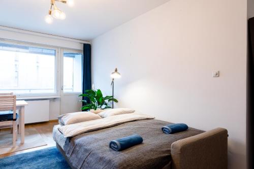 a bedroom with a large bed with two blue pillows on it at Stay Here Apartment Kamppi in Helsinki