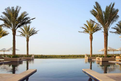 a large body of water with palm trees at Anantara Eastern Mangroves Abu Dhabi in Abu Dhabi